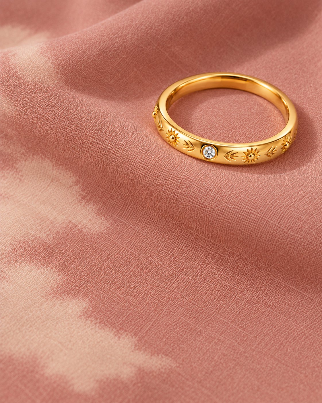 Anel fino gravado sobre o tecido rosa com nuvens marfim estampadas