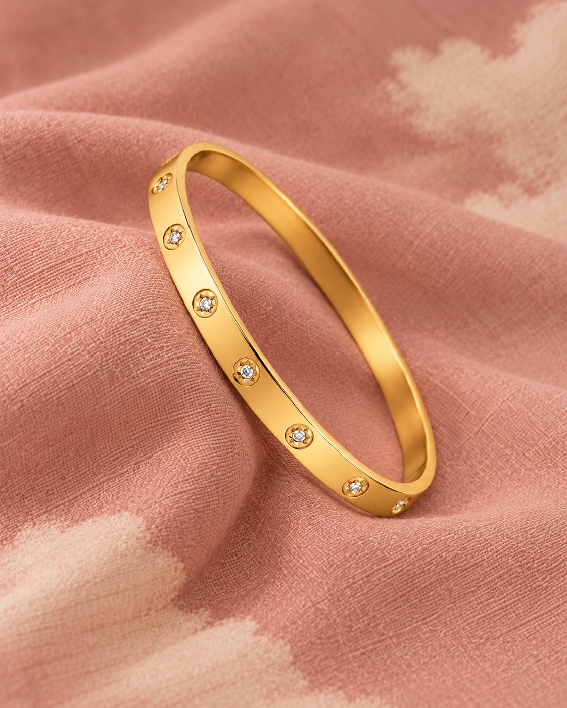 Pulseira rígida sobre o tecido rosa com nuvens marfim estampadas
